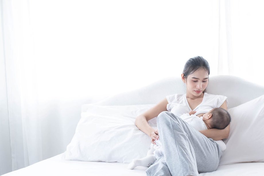ư thế phổ biến nhất khi cho con bú đó là giữ con trên đùi mẹ, hỗ trợ bằng cánh tay cùng chiều với bên ngực con bú